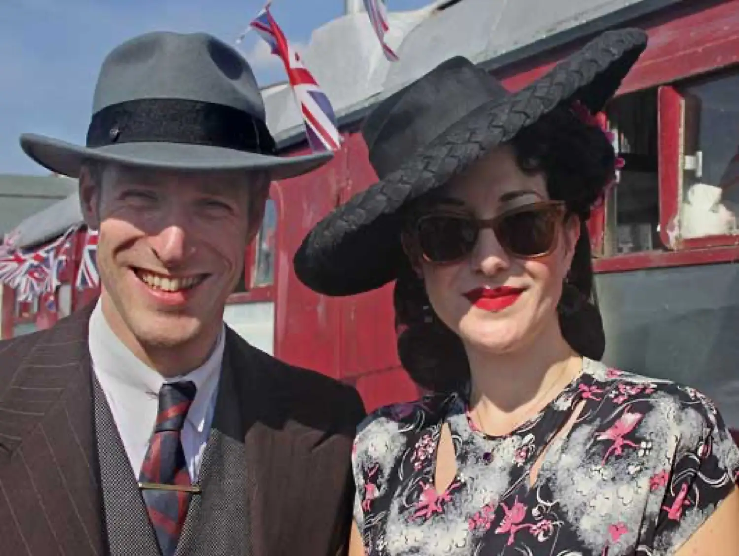 Guests in 1940s dress beside a heritage carriage