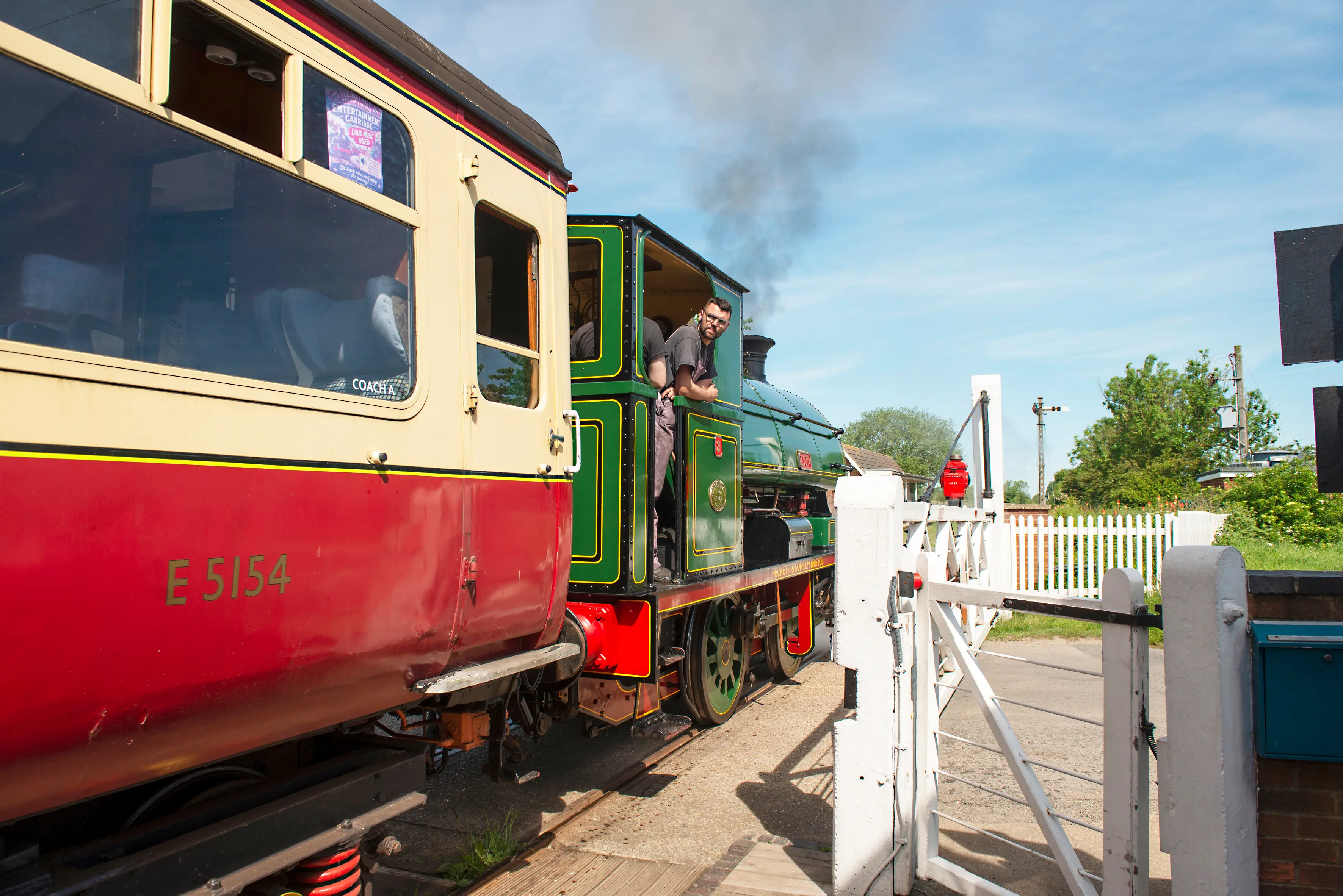 A guard walking the platform at Ludborough alongside a steam-hauled blood-and-custard train
