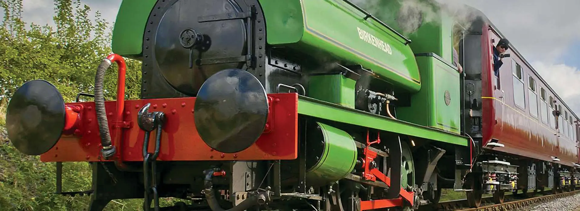 A steam locomotive and carriages at the railway